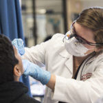 UofL dental student provides screening for a child.