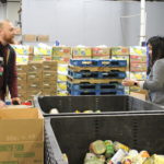 UofL nursing students John Black, left, and Glena Amante pack canned vegetables at Dare to Care Food Bank on March 14, 2018.