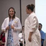 Heather Raley, left, receives her white coat from Sara Robertson, director of the University of Louisville doctor of nursing practice program, during a ceremony on Aug. 16 at the UofL Health Sciences Center.