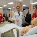 Paul Clark, center, guides UofL School of Nursing students during a clinical simulation.