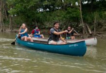 University of Louisville honors students Forest Clevenger (leading the blue canoe) Vinh Pham (leading the white canoe) paddle the Ohio River as part of a class that investigated how river towns can drive tourism and economic development. Photo courtesy John Nation.