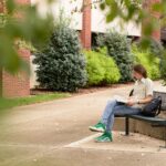 Student reading outside the College of Education and Human Development