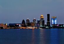 Louisville skyline at night with buildings next to the Ohio River.