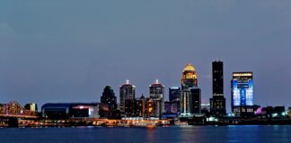 Louisville skyline at night with buildings next to the Ohio River.