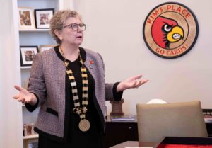 UofL President Kim Schatzel tries on the 3D printed medallion necklace. UofL photo by Ashly Cecil.