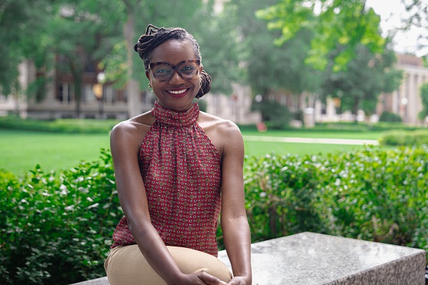 Tabitha Grier-Reed seated on a bench outside.