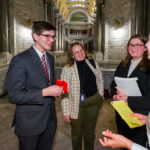 three young women and one yug man in a hallway in a government building