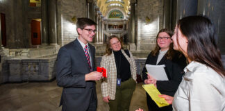 three young women and one yug man in a hallway in a government building