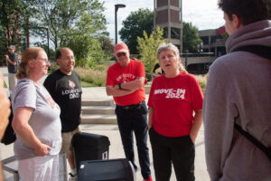 President Schatzel wears a red t-shirt and talks to new families. 