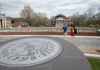 Three students walking past the 3rd Street entrance with Grawemeyer Hall and the School of Law in the background.