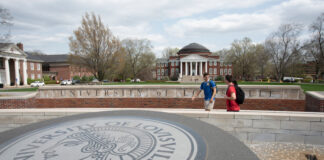 Three students walking past the 3rd Street entrance with Grawemeyer Hall and the School of Law in the background.