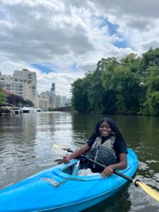 A girl in a kayak on the Chicago River with the Chicago skyline in the background