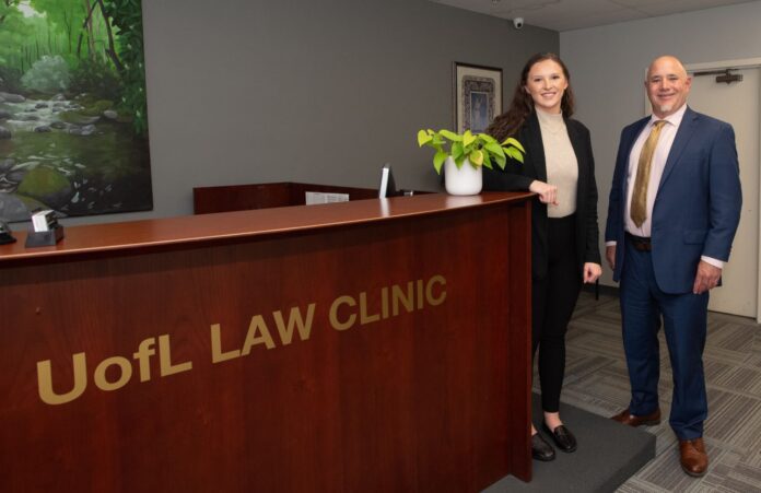 Fourth year law student Peyton Rodgers standing beside assistant professor Chris Kozoll.