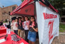 Group of students standing under a tent.