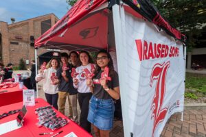 Group of students standing under a tent.