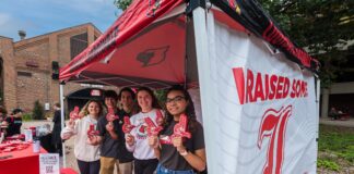 Group of students standing under a tent.