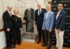 A group of administrators stand by the case containing the robe worn by namesake of UofL Law School Supreme Court Justice Louis Brandeis.