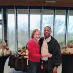 A photo of Tonya Johnson and her partner standing in front of her pottery