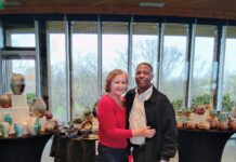 A photo of Tonya Johnson and her partner standing in front of her pottery