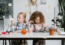 Two children exploring science at a table.