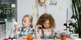 Two children exploring science at a table.