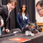 Computer Science and Engineering students Dylan Nicholson and Ruthmika Chenna explain their team's capstone project to Dr. Sam Park at the Engineering Design and Innovation Showcase.