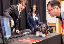 Computer Science and Engineering students Dylan Nicholson and Ruthmika Chenna explain their team's capstone project to Dr. Sam Park at the Engineering Design and Innovation Showcase.