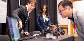 Computer Science and Engineering students Dylan Nicholson and Ruthmika Chenna explain their team's capstone project to Dr. Sam Park at the Engineering Design and Innovation Showcase.