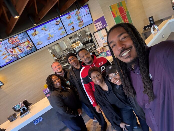 Ethan McNary at a Taco Bell restaurant with team members