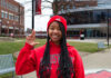 Girl in red sweatshirt holding up the 'L' sign