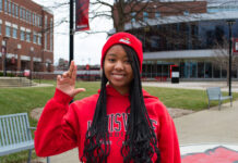 Girl in red sweatshirt holding up the 'L' sign